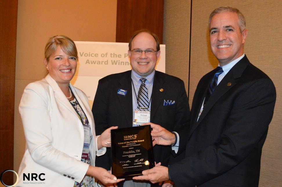 Voice of the People award presentation, three people holding the award