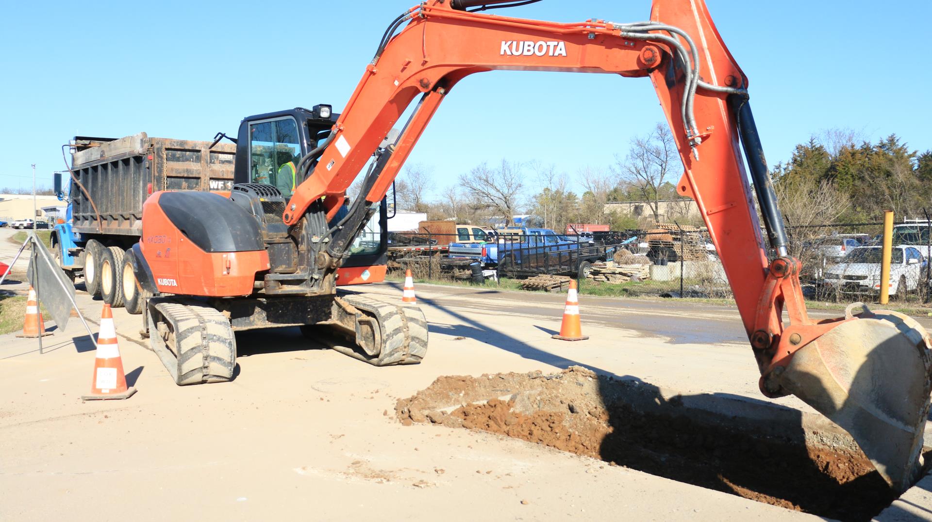 Photo of Backhoe digging hole to repair pipe