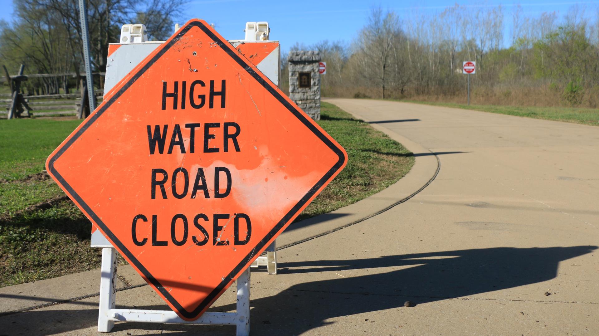 flood photo with sign high waters road closed