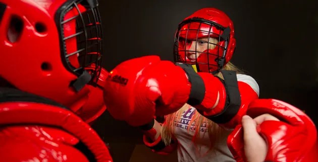 Woman wearing protective gear, learning self-defense